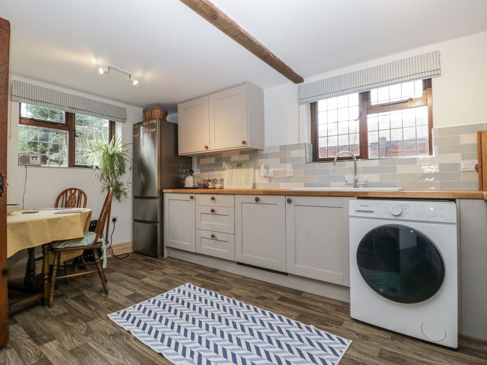 A kitchen with cabinets and a washing machine at Magpie Cottage Worcester