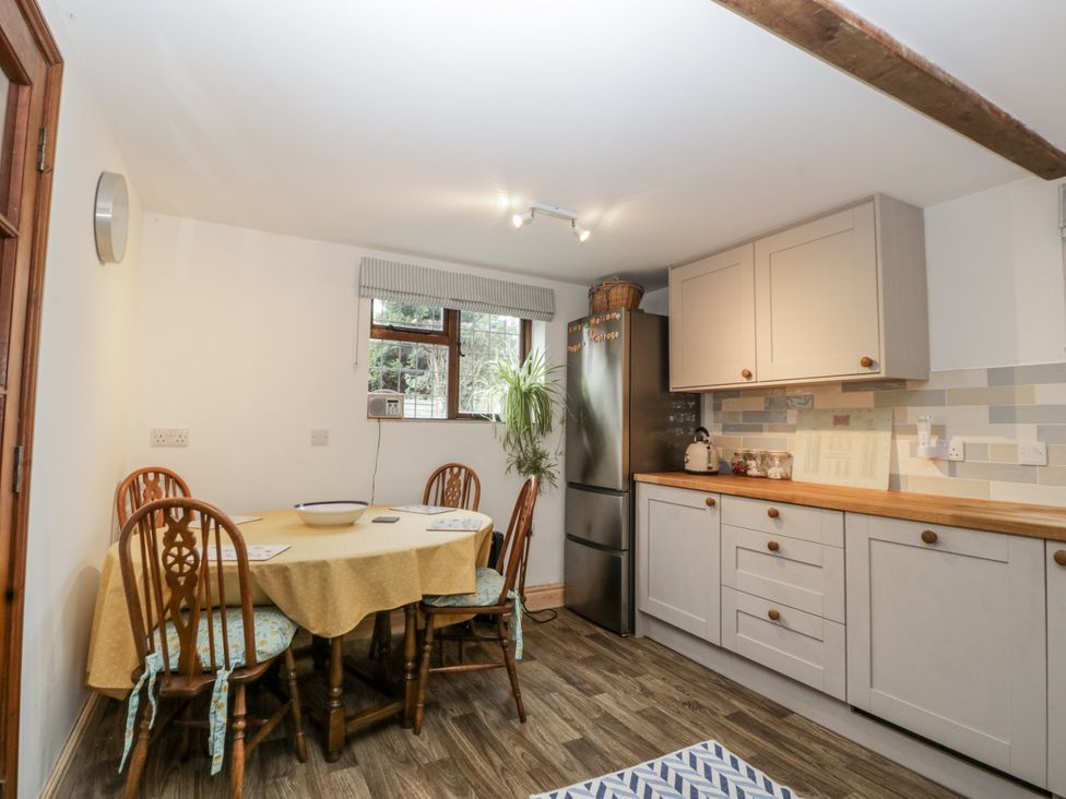 A kitchen with a table and chairs at Magpie Cottage in Worcester