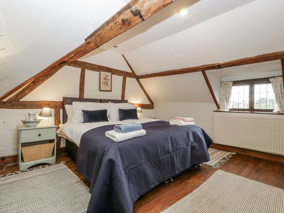 A bedroom with a bed and bedside table at Magpie Cottage in Worcester