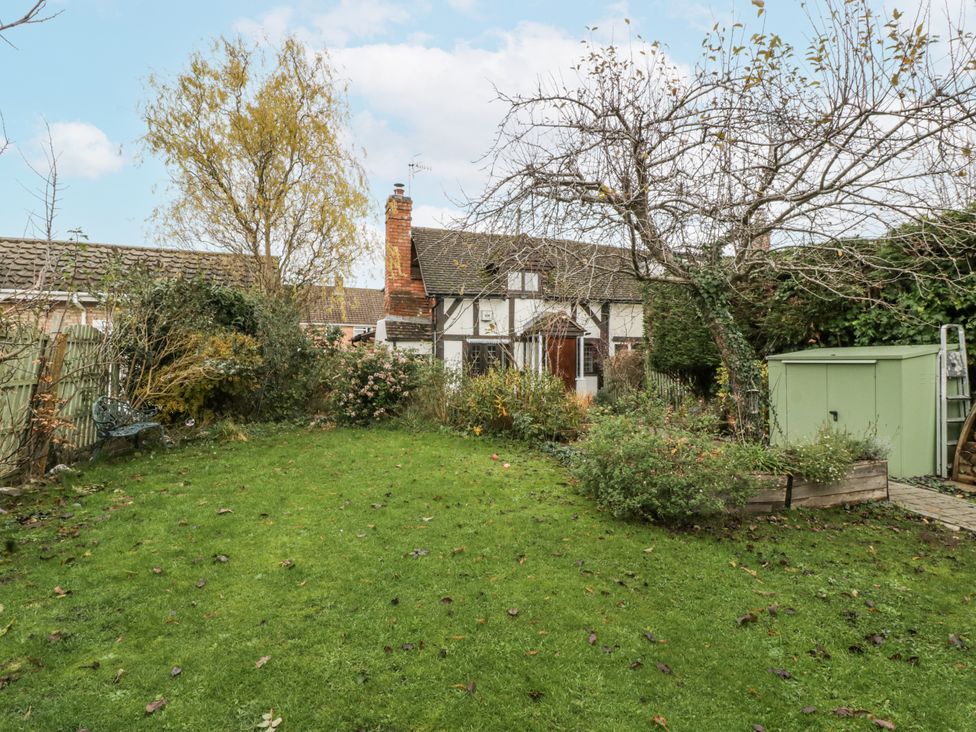 A garden with grass and trees at Magpie Cottage in Worcester