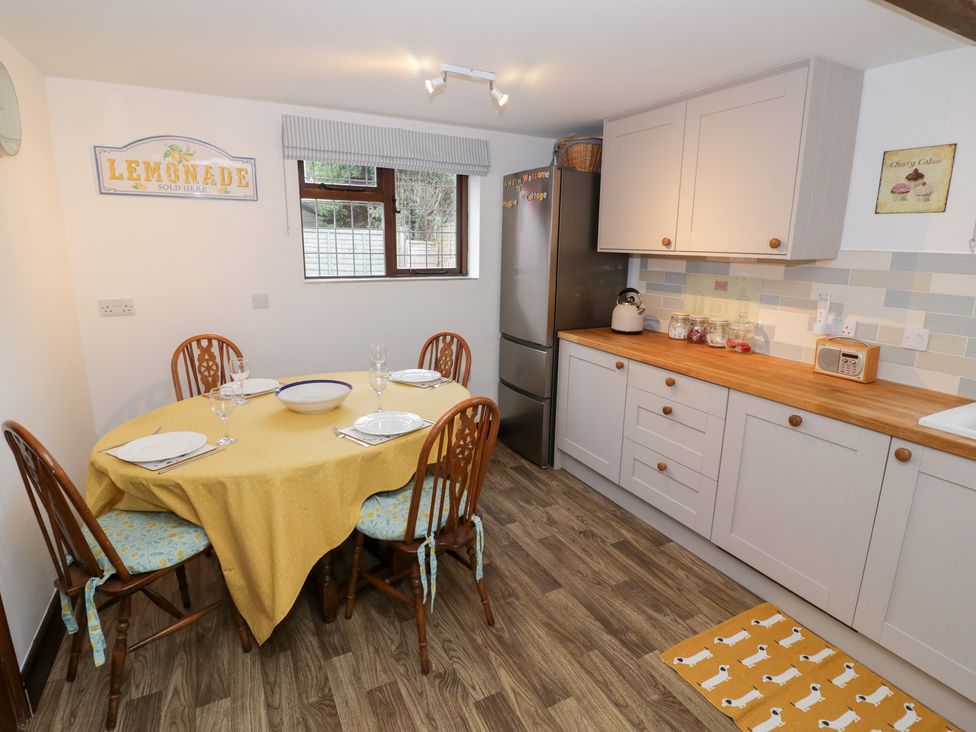A kitchen with dining table and chairs at Magpie Cottage Powick near Callow End
