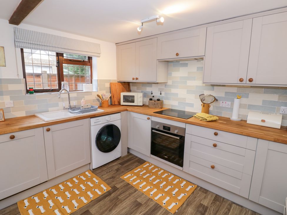 A kitchen with appliances and a window at Magpie Cottage in Powick near Callow End