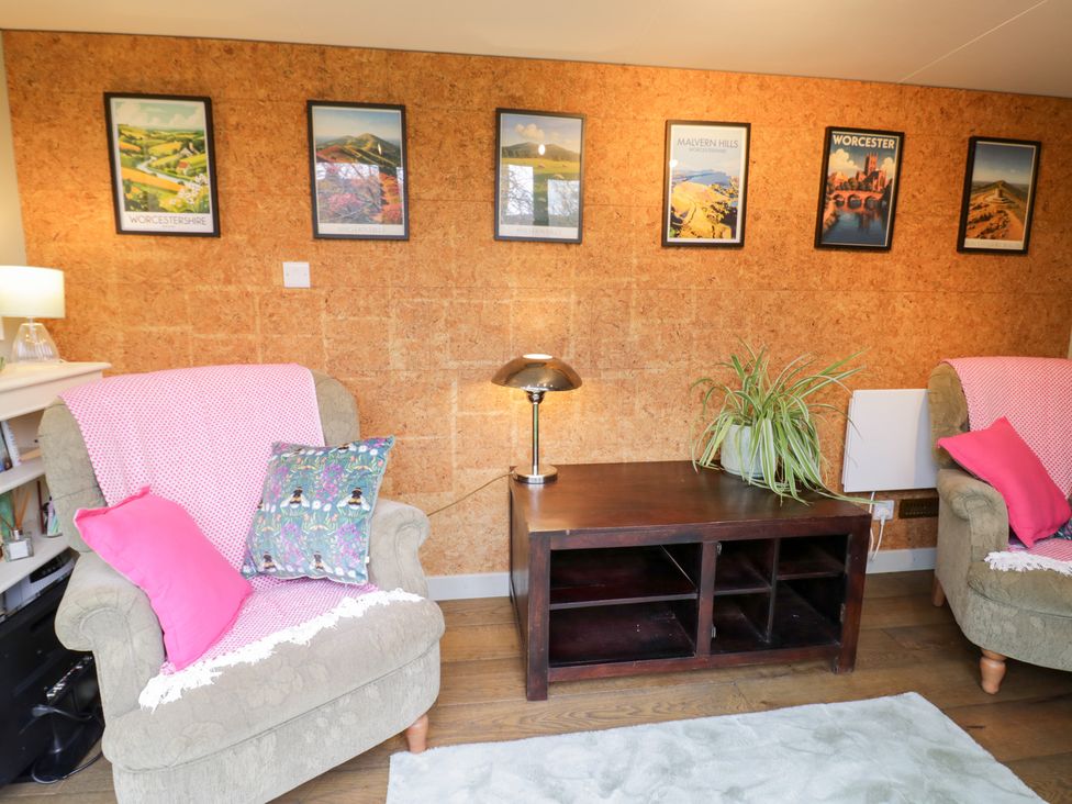 A living room with armchairs and a coffee table at Magpie Cottage in Powick near Callow End