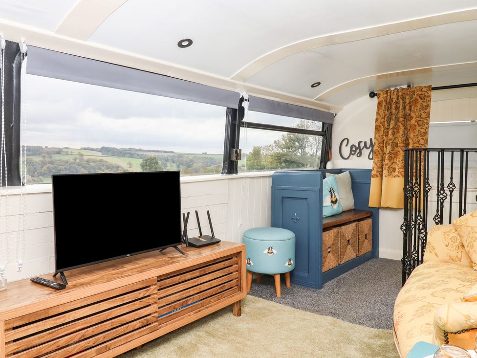 A living room with a television and seating at The Bus on the Hill