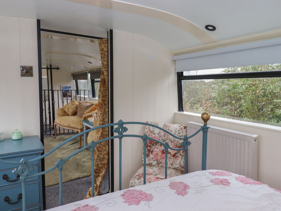 A bedroom with a bed and a chair at The Bus on the Hill