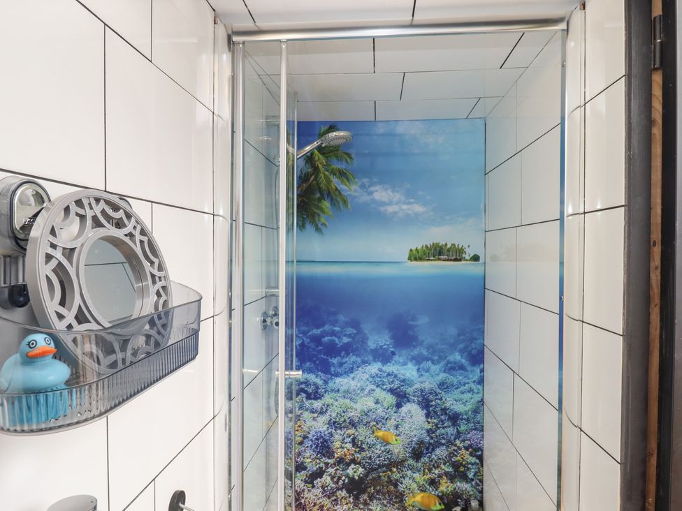 A shower with a decorative mirror and a rubber duck at The Bus on the Hill