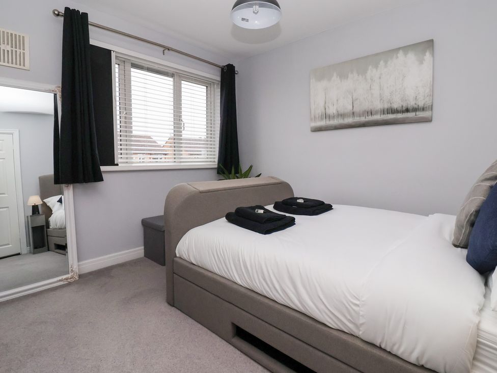 A bedroom with a bed and mirror at 127 Bellhouse Way in York