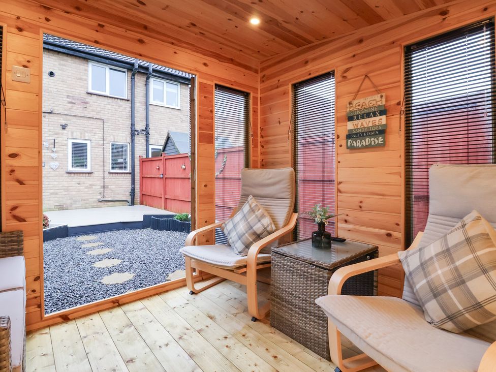 A conservatory with chairs and a table at 127 Bellhouse Way in York