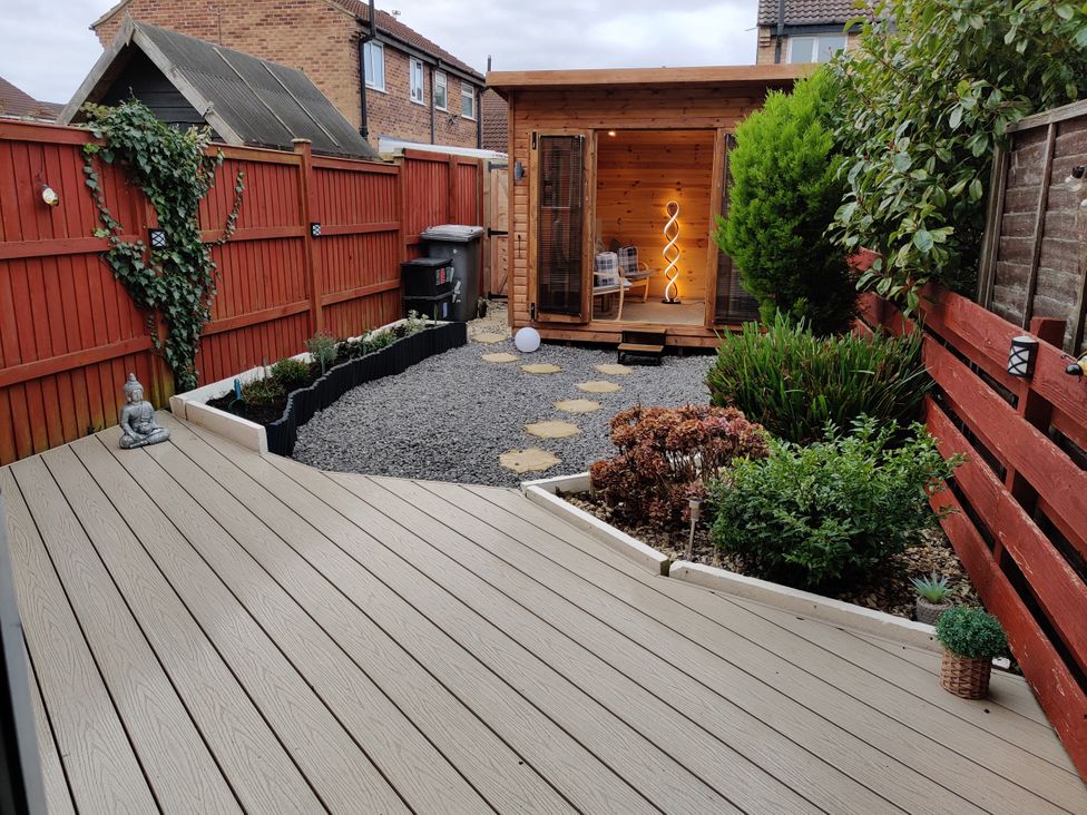 A garden with a wooden deck, gravel, and a shed at 127 Bellhouse Way, York