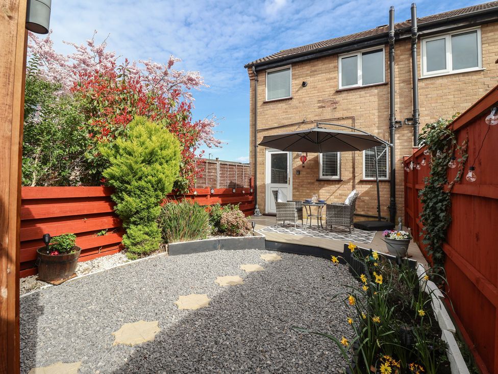A garden with a table and chairs beside an umbrella at 127 Bellhouse Way York