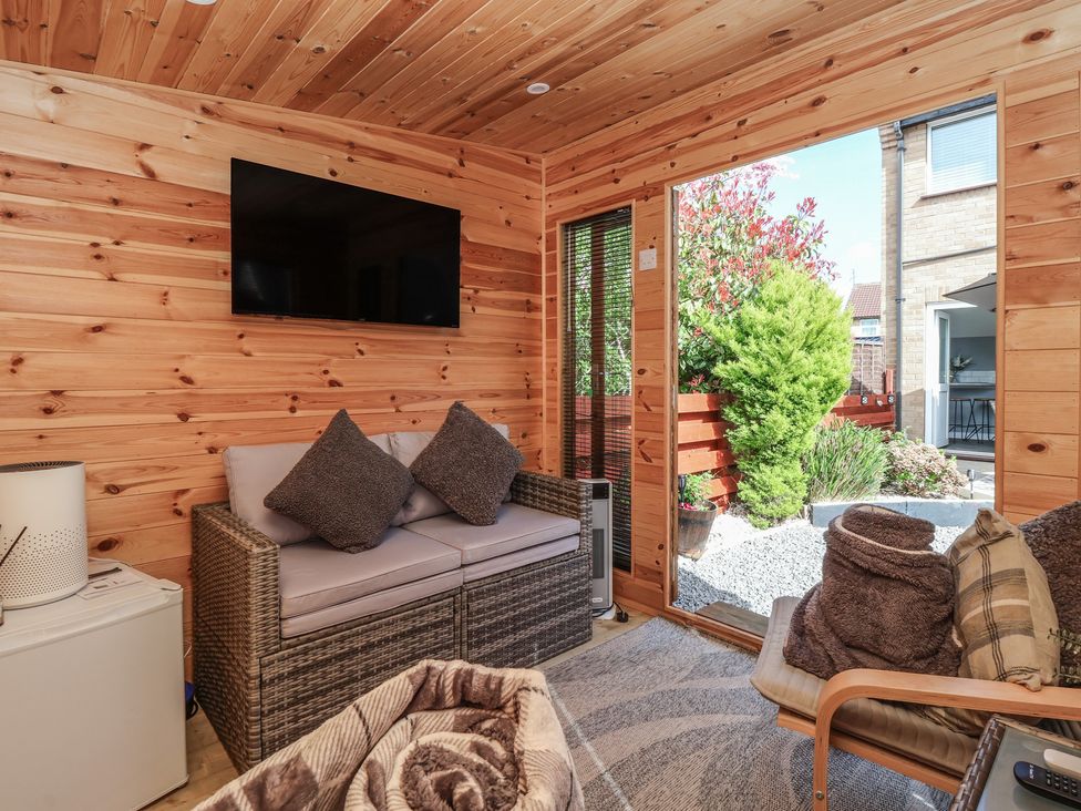 A conservatory with a sofa and television at 127 Bellhouse Way in York