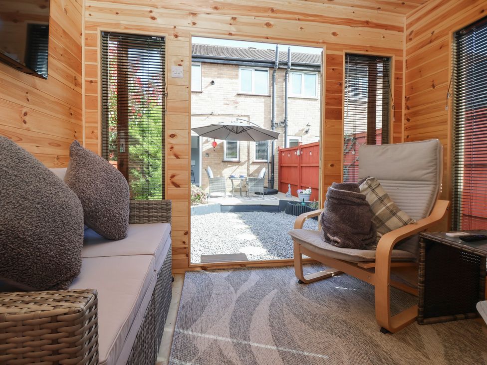 A snug with a sofa and armchair overlooking a garden at 127 Bellhouse Way York