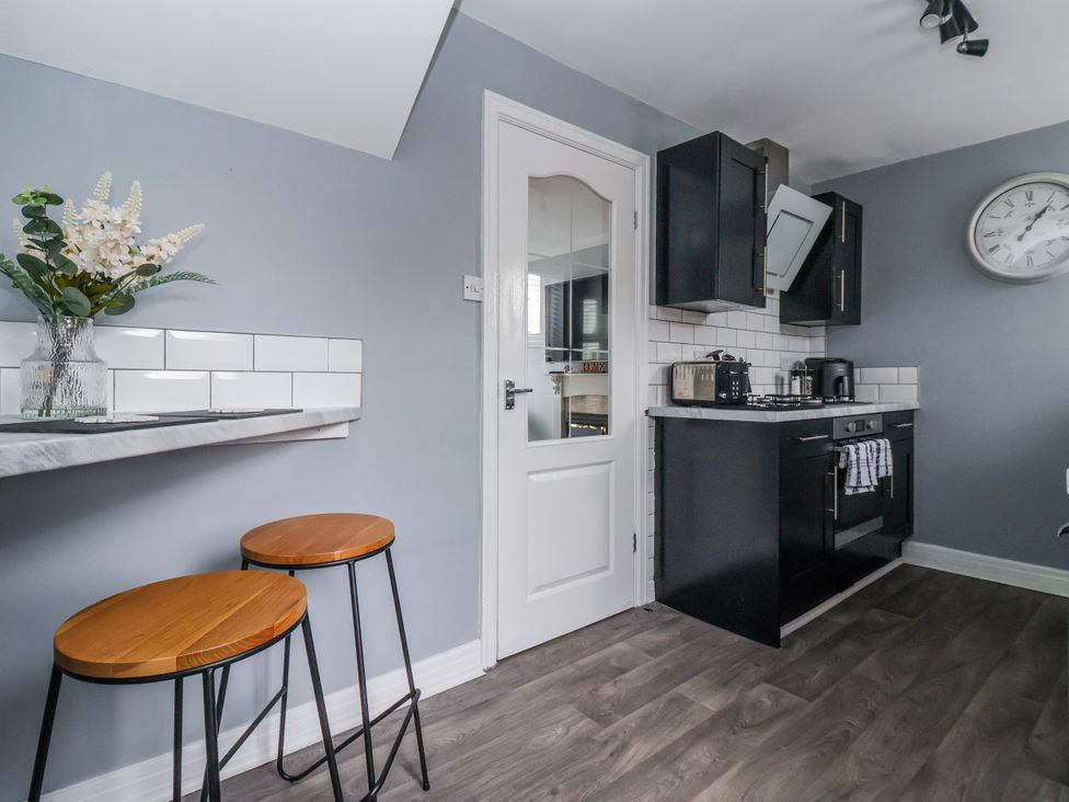 A kitchen with black cabinets and bar stools at 127 Bellhouse Way York