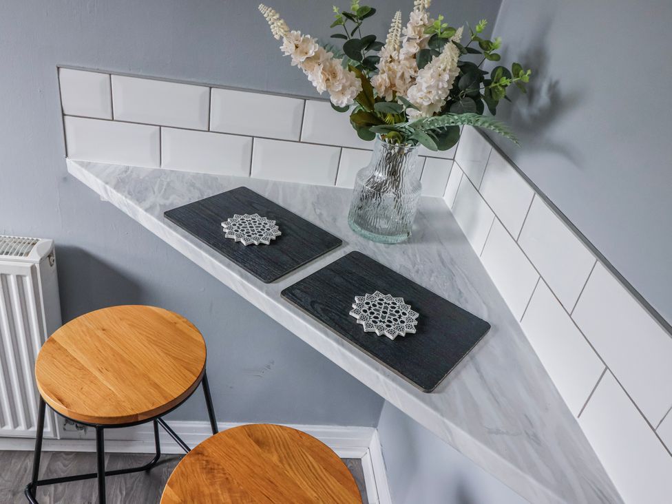 A kitchen corner with a vase of flowers and wooden stools at 127 Bellhouse Way in York