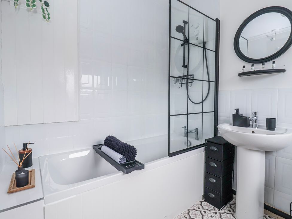 A bathroom with a bathtub, shower, mirror, and sink at 127 Bellhouse Way in York