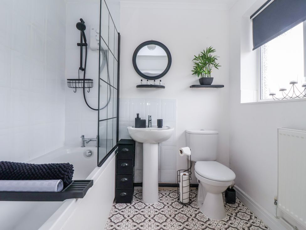 A bathroom with a bathtub, sink, toilet, and mirror at 127 Bellhouse Way in York