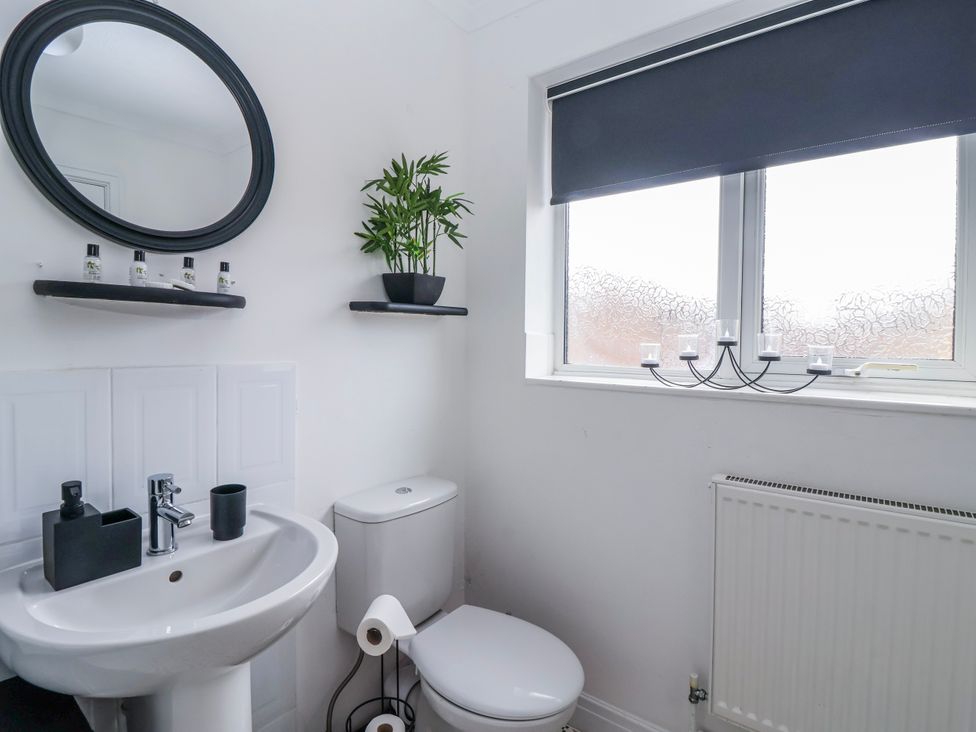 A bathroom with a sink, mirror and toilet at 127 Bellhouse Way in York