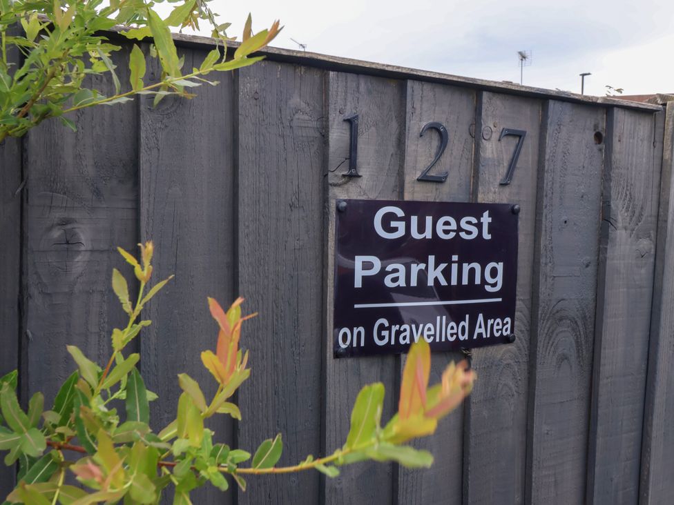 A sign for guest parking on a wooden fence at 127 Bellhouse Way, York