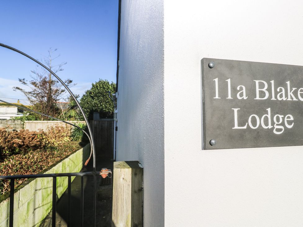 A sign on the wall indicating 11a Blake Lodge in Crantock
