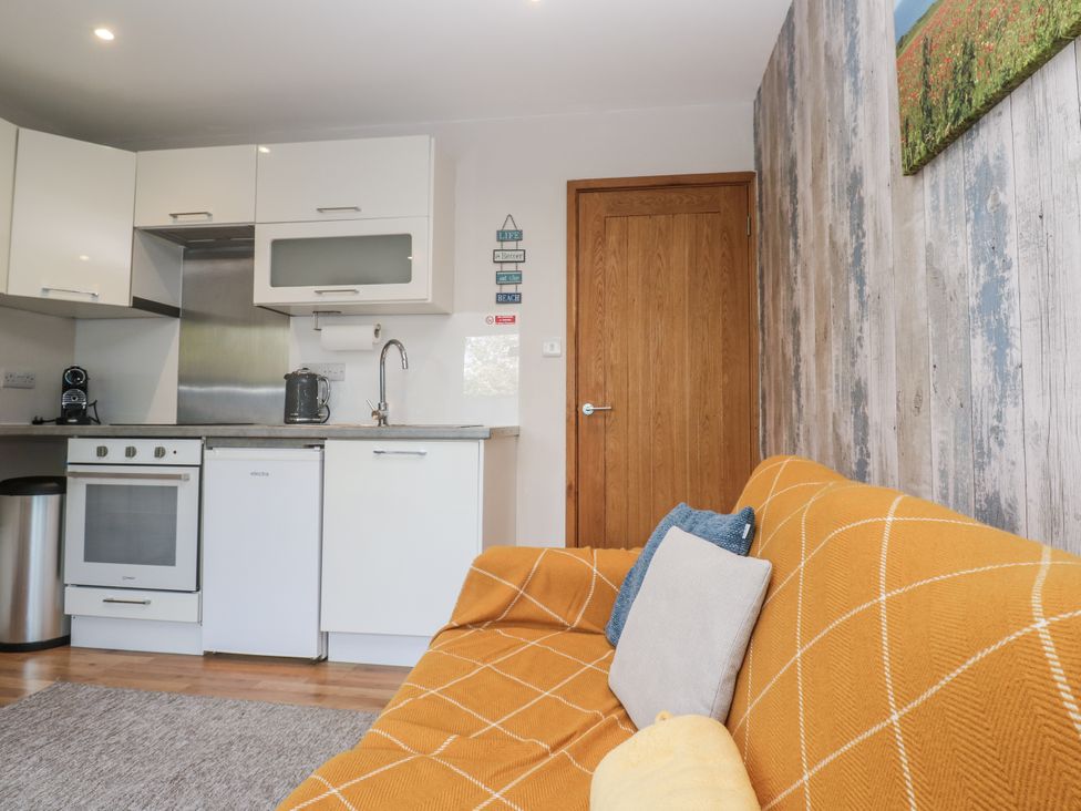 A kitchen with appliances and a sofa at Blake Lodge in Crantock