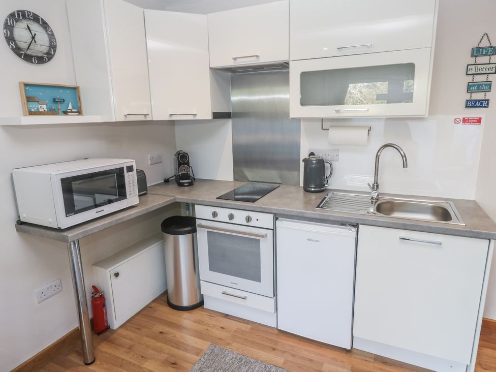 A kitchen with appliances and cabinets at Blake Lodge in Crantock