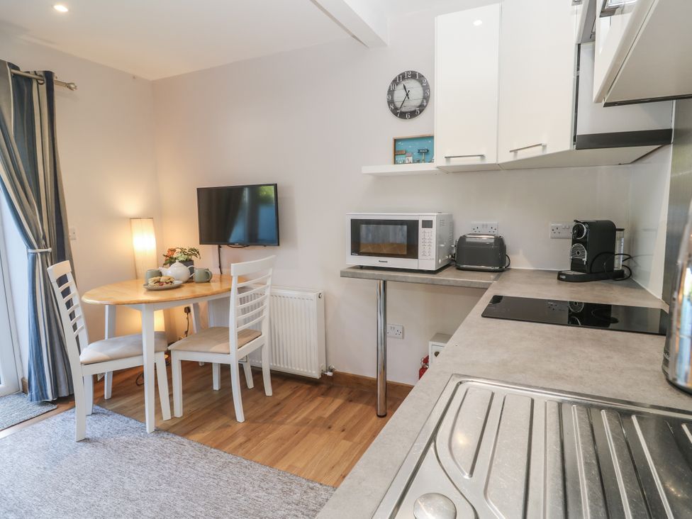 A kitchen with dining table and appliances at Blake Lodge in Crantock