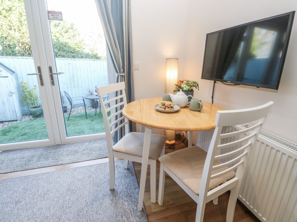 A dining room with a round table and chairs at Blake Lodge in Crantock