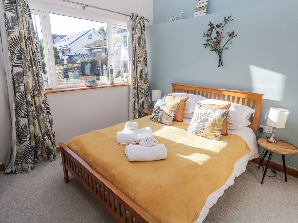 A bedroom with a bed, pillows, and curtains at Blake Lodge in Crantock