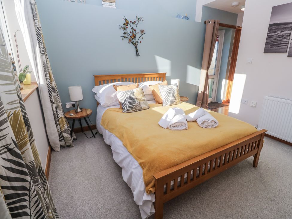 A bedroom with a double bed and side table at Blake Lodge in Crantock