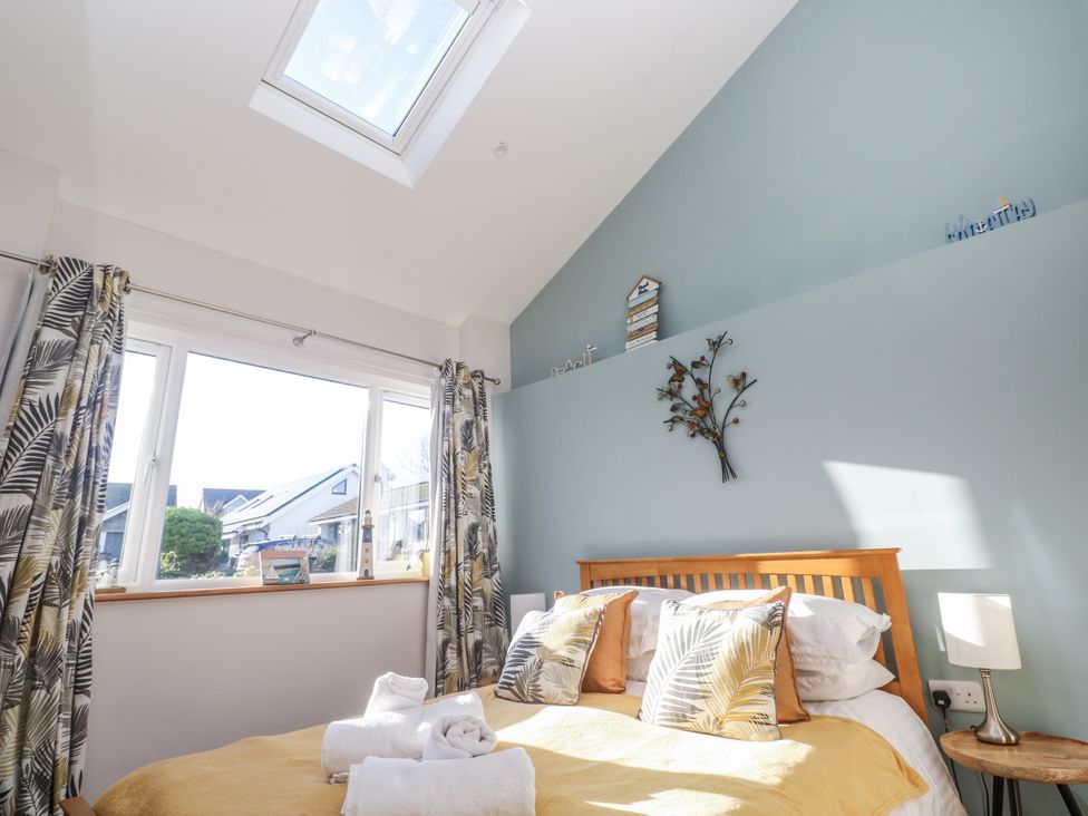 A bedroom with a bed and window at Blake Lodge Crantock