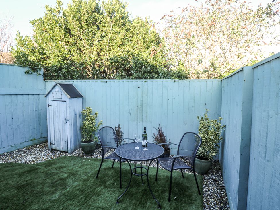 A garden with a table and chairs at Blake Lodge Crantock