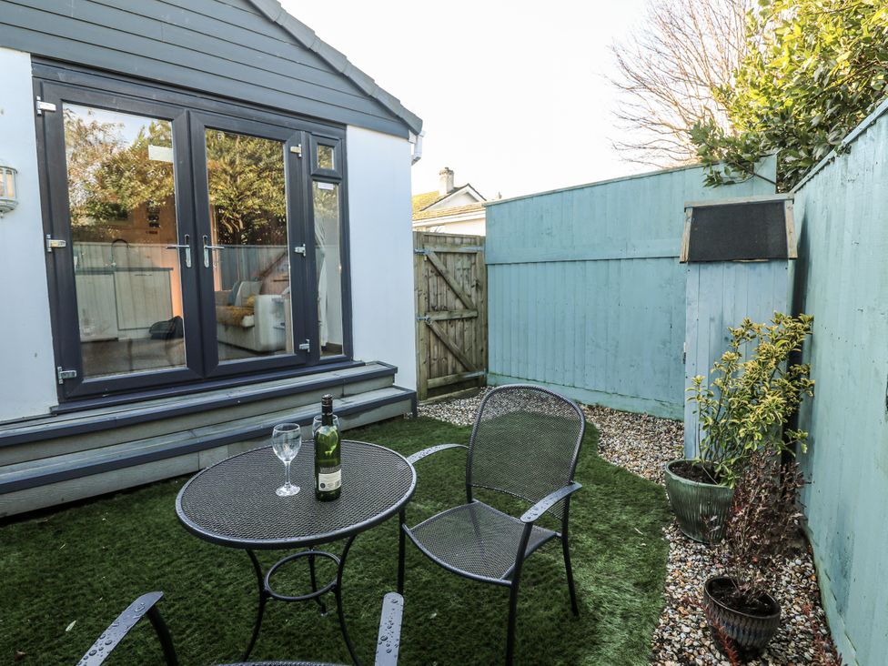 A garden with a table and chairs at Blake Lodge in Crantock
