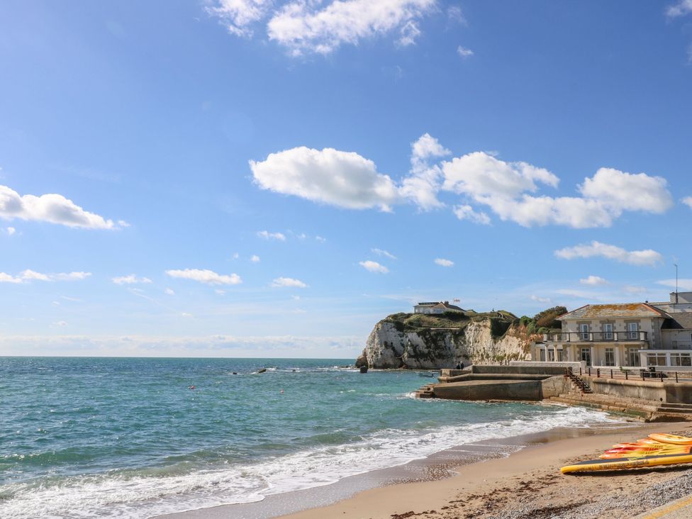 A beach with a cliff and buildings near the ocean at Blake Lodge in Crantock