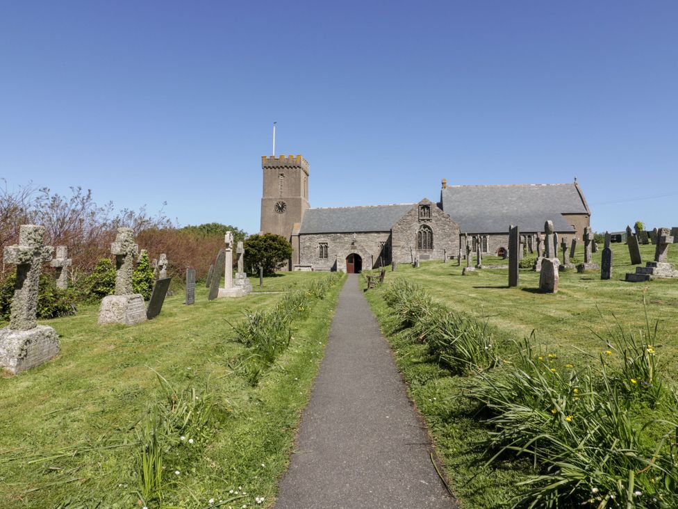 A church and graveyard with a pathway in Crantock at Blake Lodge