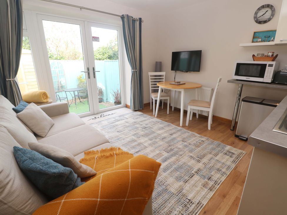 A living room with a sofa and dining table at Blake Lodge in Crantock