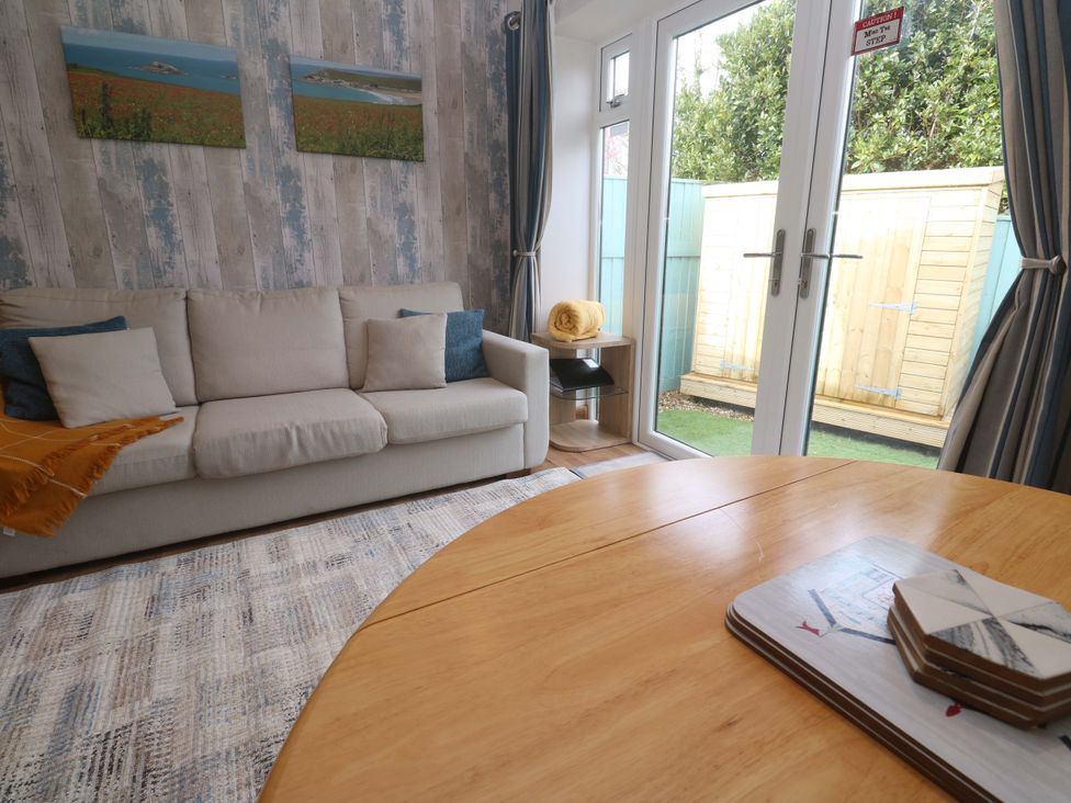 A living room with a sofa and table at Blake Lodge in Crantock