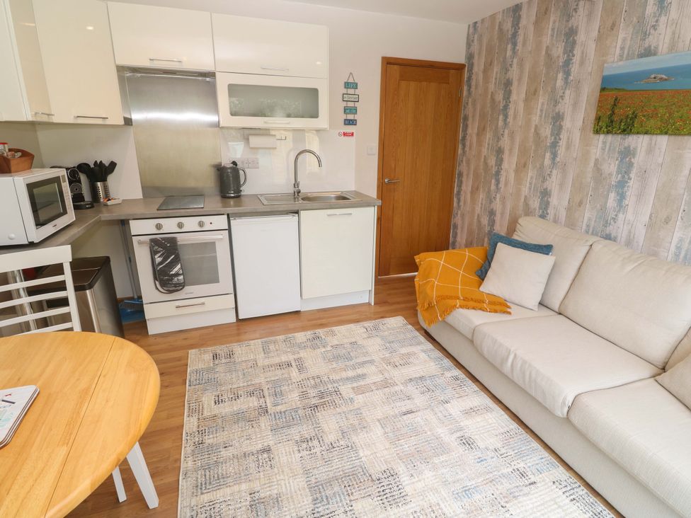 A kitchen with a sofa and dining table at Blake Lodge in Crantock