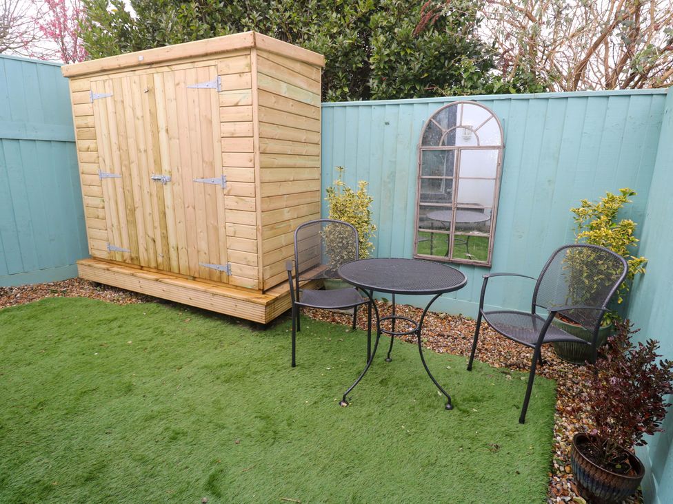 A garden with a shed, table, and chairs at Blake Lodge Crantock
