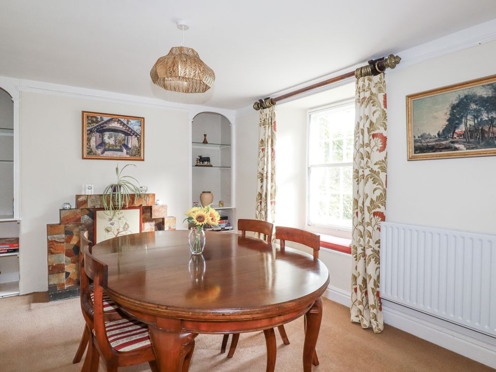 A dining room with a wooden table and chairs at Tresarrett Manor in Bodmin