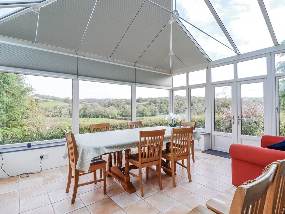 A conservatory with a table and chairs at Tresarrett Manor in Bodmin