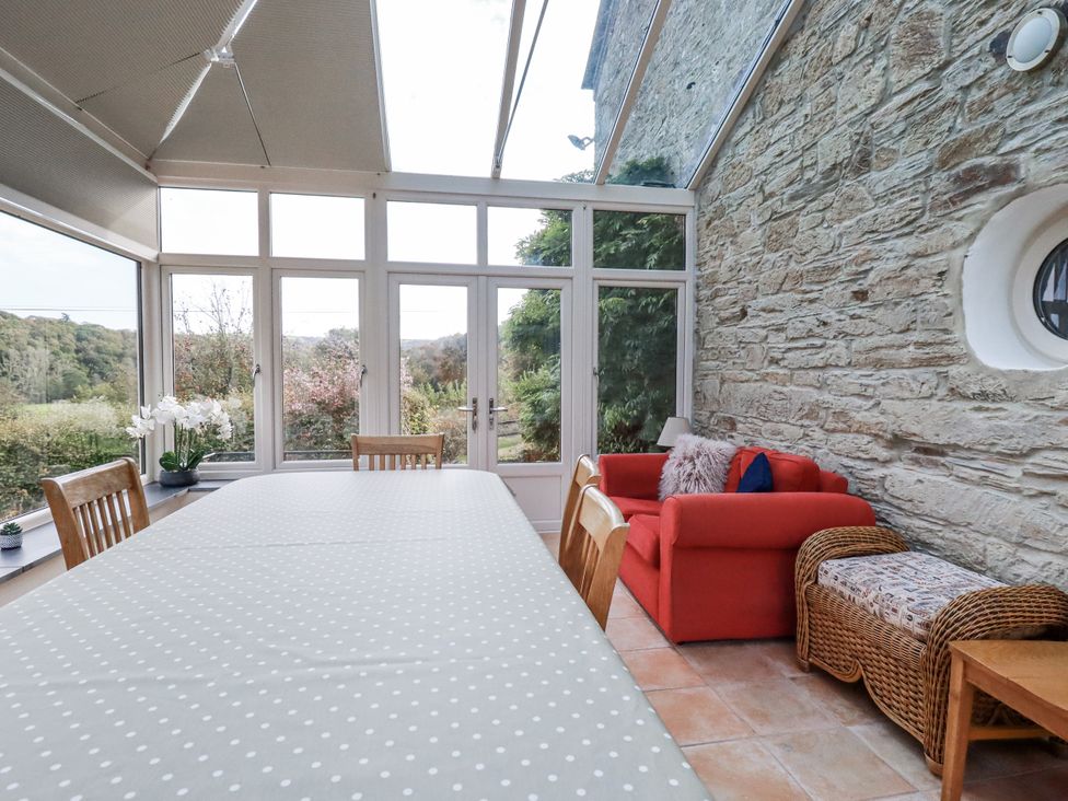 A conservatory with a table and chairs at Tresarrett Manor in Bodmin