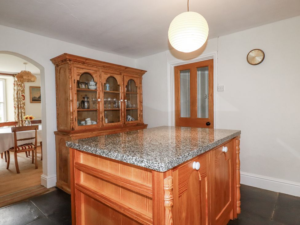 A kitchen with a granite countertop and wooden cupboard at Tresarrett Manor in Bodmin