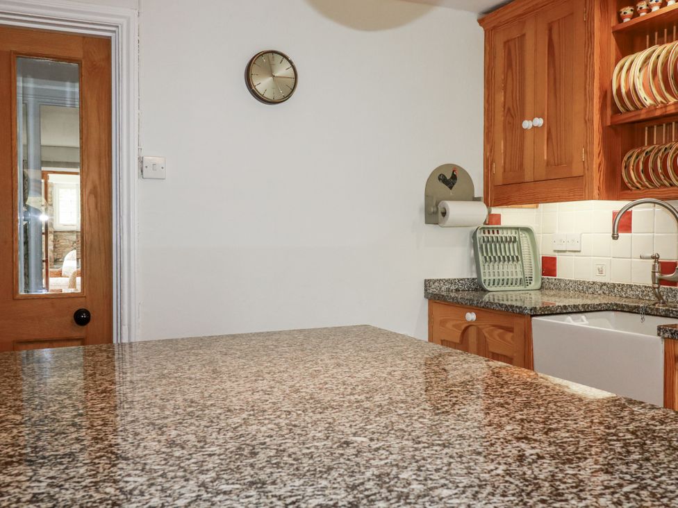 A kitchen with a granite countertop and wall clock at Tresarrett Manor in Bodmin