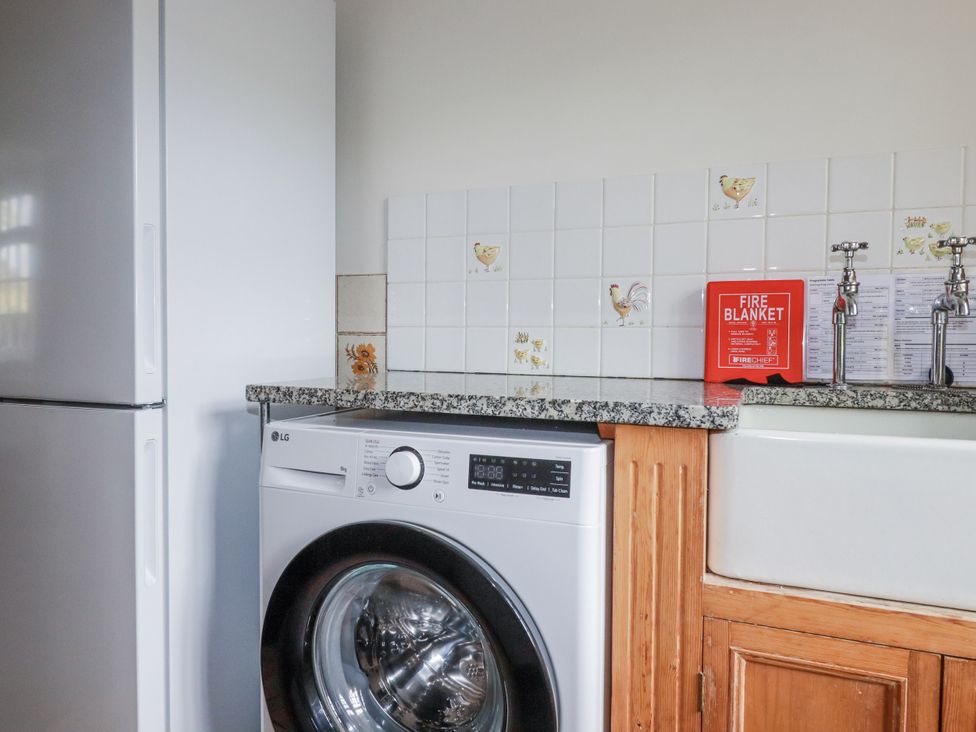 A utility room with a washing machine and refrigerator at Tresarrett Manor in Bodmin