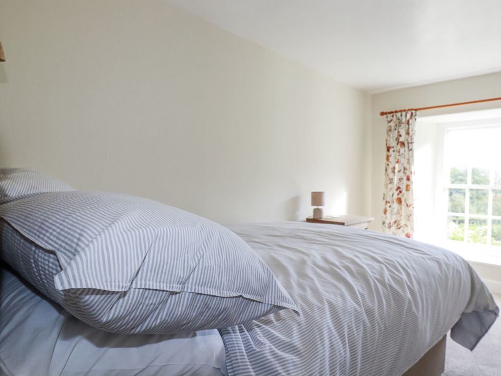 A bedroom with a bed and window at Tresarrett Manor in Bodmin