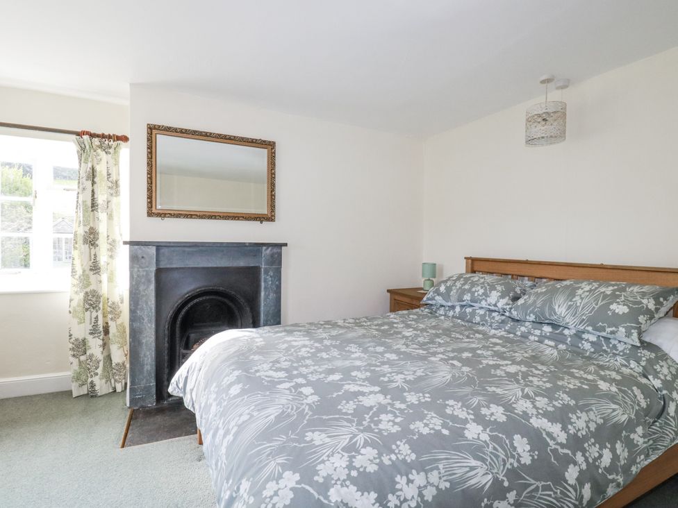A bedroom with a bed and fireplace at Tresarrett Manor in Bodmin