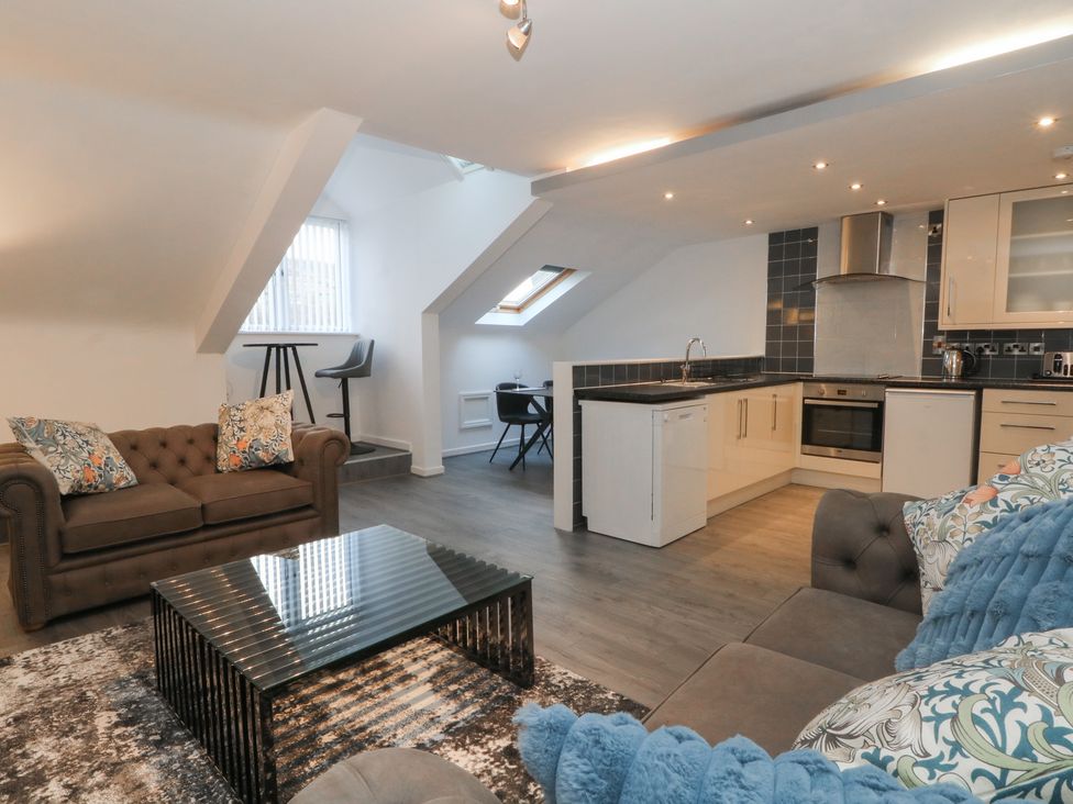 A living room and kitchen area with seating and kitchen fixtures at 32B Bank Street Rossendale