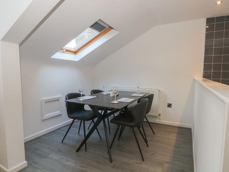 A dining room with a table and chairs at 32B Bank Street in Rossendale