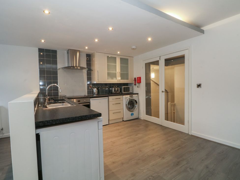 A kitchen with appliances including a sink and washing machine at 32B Bank Street Rossendale