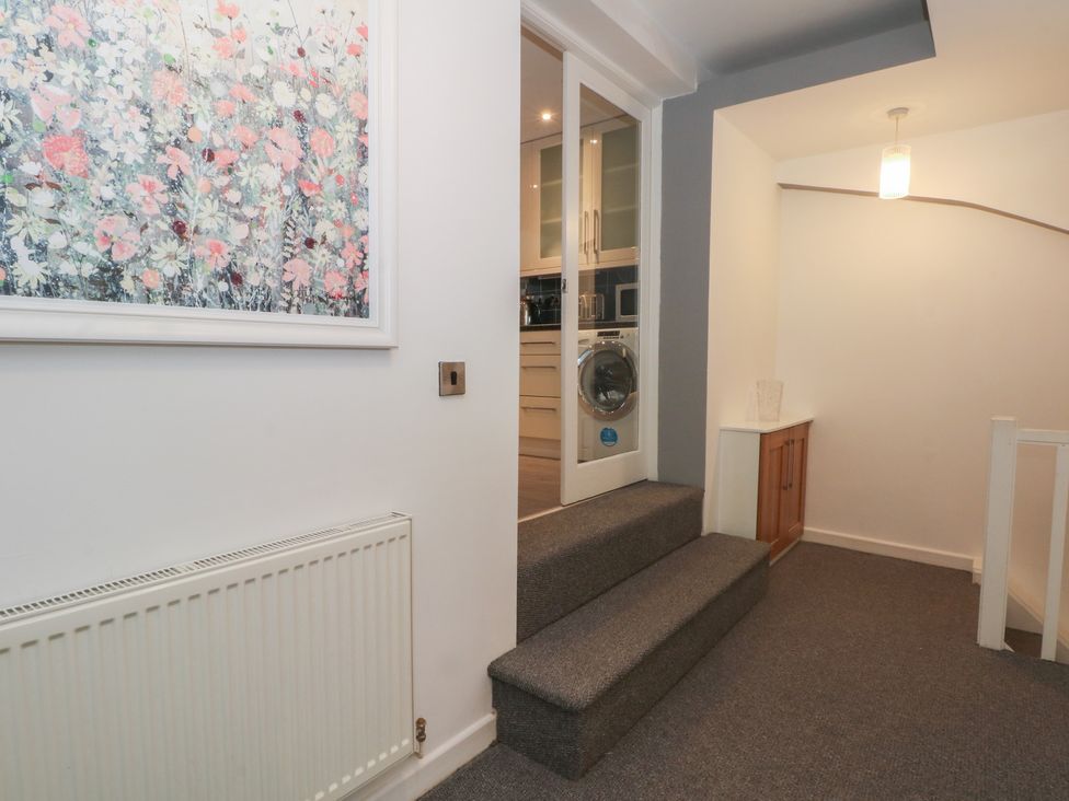 A hallway with stairs and a washing machine at 32B Bank Street, Rossendale